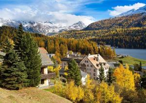 a house on a hill with a lake and mountains at Studio in St Moritz Champfer in St. Moritz