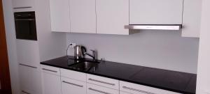 a kitchen with white cabinets and a black counter top at Studio in St Moritz Champfer in St. Moritz