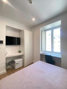 a bedroom with a bed and a desk and a window at Hotel Europeo Napoli in Naples