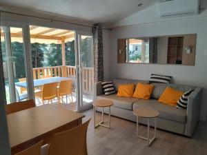 a living room with a couch and a table at Camping 3 étoiles - Piscine - ccbfii0 in Châteauneuf-de-Gadagne