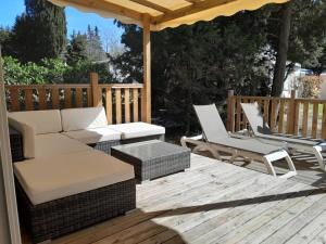 a patio with a couch and chairs on a wooden deck at Camping 3 étoiles - Piscine - ccbfii0 in Châteauneuf-de-Gadagne