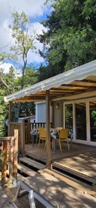 a wooden deck with tables and chairs on it at Camping 3 étoiles - Piscine - ccbfii0 in Châteauneuf-de-Gadagne