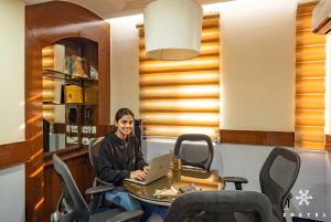 a woman sitting at a table with a laptop at Zostel Delhi in New Delhi +30 photos