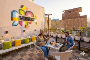 two people sitting at a table on a patio at Zostel Delhi in New Delhi