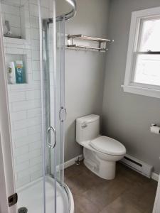 a bathroom with a toilet and a glass shower at Pet-Friendly Private Beach Oceanfront Cottage in Charlestown +42 photos