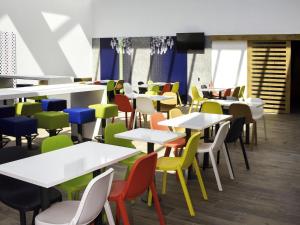 a dining room with tables and colorful chairs at ibis budget Langres in Langres
