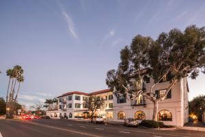 a large building with a tree in front of it at Montecito Inn in Santa Barbara