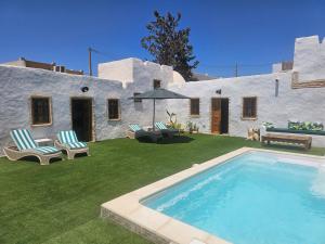 a yard with a swimming pool in front of a house at Dar Chauphaly in Houmt Souk