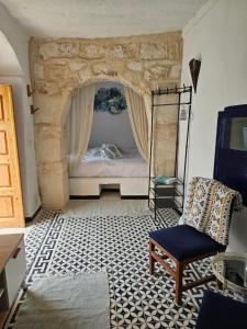 a bedroom with a bed and a chair in a room at Dar Chauphaly in Houmt Souk