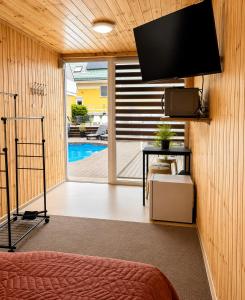 a room with a tv on a wall with a pool at Pool Hause Palanga in Palanga +2 photos