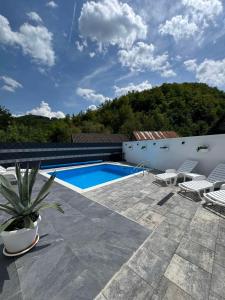 a patio with a pool and chairs and a house at Pool House in Toplica