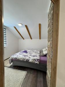 a bedroom with a bed and a brick wall at Pool House in Toplica