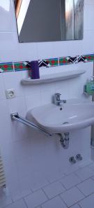 a bathroom with a white sink and a mirror at Gemütliches Doppelzimmer mit Balkon in Furth im Wald +4 photos
