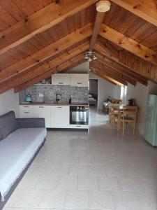 eine Küche und ein Wohnzimmer mit Sofa und Tisch in der Unterkunft Christos Studios in Zóla