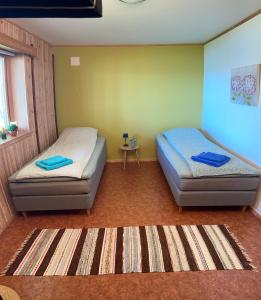 a room with two beds and a table in it at Comfortable B&B near Senja in Brostadbotn