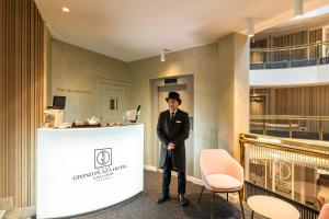 a man standing next to a counter in a lobby at Grand Plaza Hotel & Wellness in Andorra la Vella +136 photos