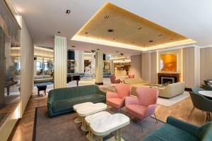 a living room with couches and tables and chairs at Grand Plaza Hotel & Wellness in Andorra la Vella