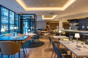 a restaurant with tables and chairs and a bar at Grand Plaza Hotel & Wellness in Andorra la Vella