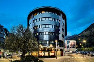 a tall glass building with a round top at Grand Plaza Hotel & Wellness in Andorra la Vella