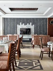 a dining room with tables and chairs and a fireplace at Millennium Inn Hotel Naran in Naran