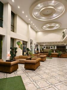 a lobby with couches and tables in a building at Millennium Inn Hotel Naran in Naran