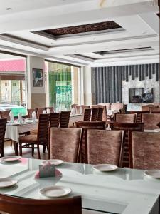 a restaurant with tables and chairs and a fireplace at Millennium Inn Hotel Naran in Naran