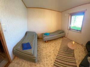 a small room with two beds and a window at Comfortable B&B near Senja in Brostadbotn