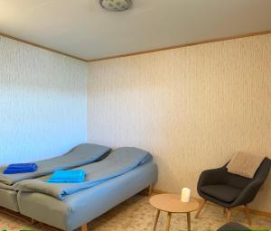 a room with a bed and a chair and a clock at Comfortable B&B near Senja in Brostadbotn