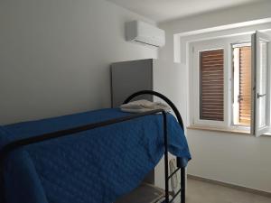 a bedroom with a blue bed with a window at Cilento My Home in Albanella +22 photos