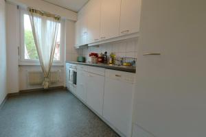 a kitchen with white cabinets and a window at Cozy Apartment with Easy Access to Bern in Bern