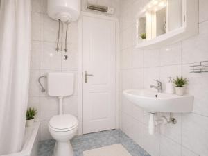 a white bathroom with a toilet and a sink at Quiet Oasis in the Heart of Old Town- two kitchen,3bath in Split +29 photos