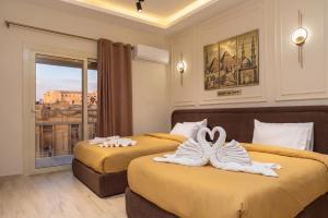 zwei Betten in einem Hotelzimmer mit Handtüchern in der Unterkunft ClA Haven-Calma in Kairo