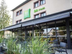 a building with a lot of windows and chairs at ibis Styles Bâle-Mulhouse Aéroport in Blotzheim