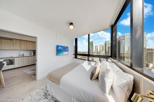 a bedroom with a large bed and large windows at District 225 Condo by Ionica in Miami