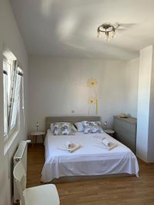 a bedroom with a white bed and a chair at Apartment Place 2 Stay in Hvar