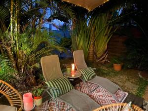 a patio with two chairs and a table with a candle at Ti Kaz Ravinala in Ravine des Cabris