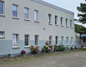 a white building with flowers in front of it at Ferienwohnung in Georgenthal in Georgenthal