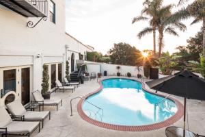 a large swimming pool with a balcony overlooking a beach at Montecito Inn in Santa Barbara