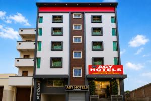 a tall white building with a red sign in front of it at Agy Hotels in Pune +31 photos