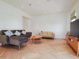 a living room with a couch and a tv at Eden's Bloomdale in St Austell