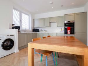 a kitchen with a wooden table and a microwave at Eden's Bloomdale in St Austell