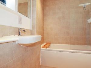 a bathroom with a sink and a bath tub at Eden's Bloomdale in St Austell +12 photos