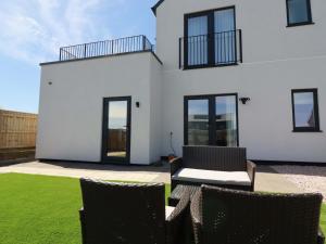 a white house with two chairs and a table at Eden's Bloomdale in St Austell
