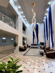 a large lobby with couches and a chandelier at Afsona Hotel in Bukhara