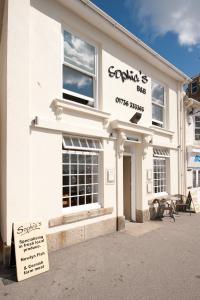 a white building with a sign in front of it at Sophia's in Penzance