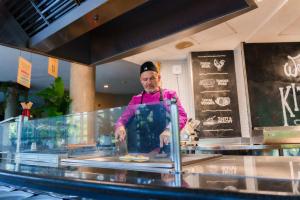a man standing behind a counter preparing food at Spirit Hotel Gran Bilbao in Bilbao