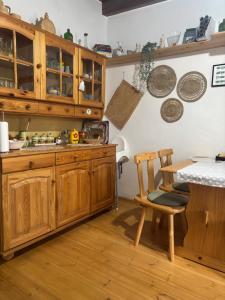 a kitchen with wooden cabinets and a table at Sárga-part Vendégház in Cserépváralja