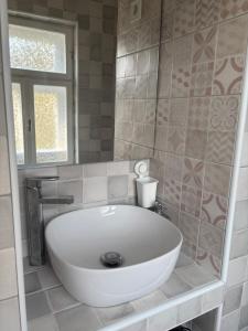 a white bath tub in a bathroom with a window at Sárga-part Vendégház in Cserépváralja +2 photos