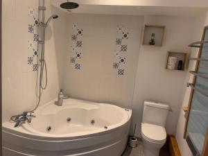 a white bathroom with a tub and a toilet at Le clocher d Ardres in Ardres