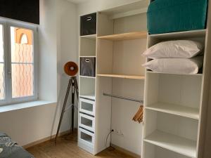 a room with white shelves and a window at Le clocher d Ardres in Ardres